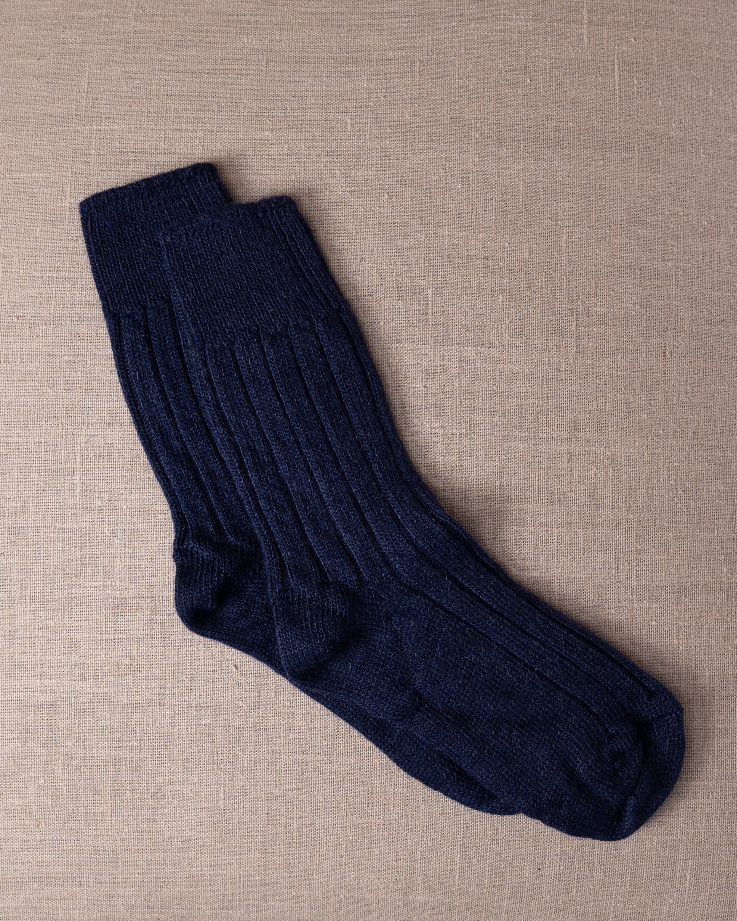 Navy blue socks on a beige textured background