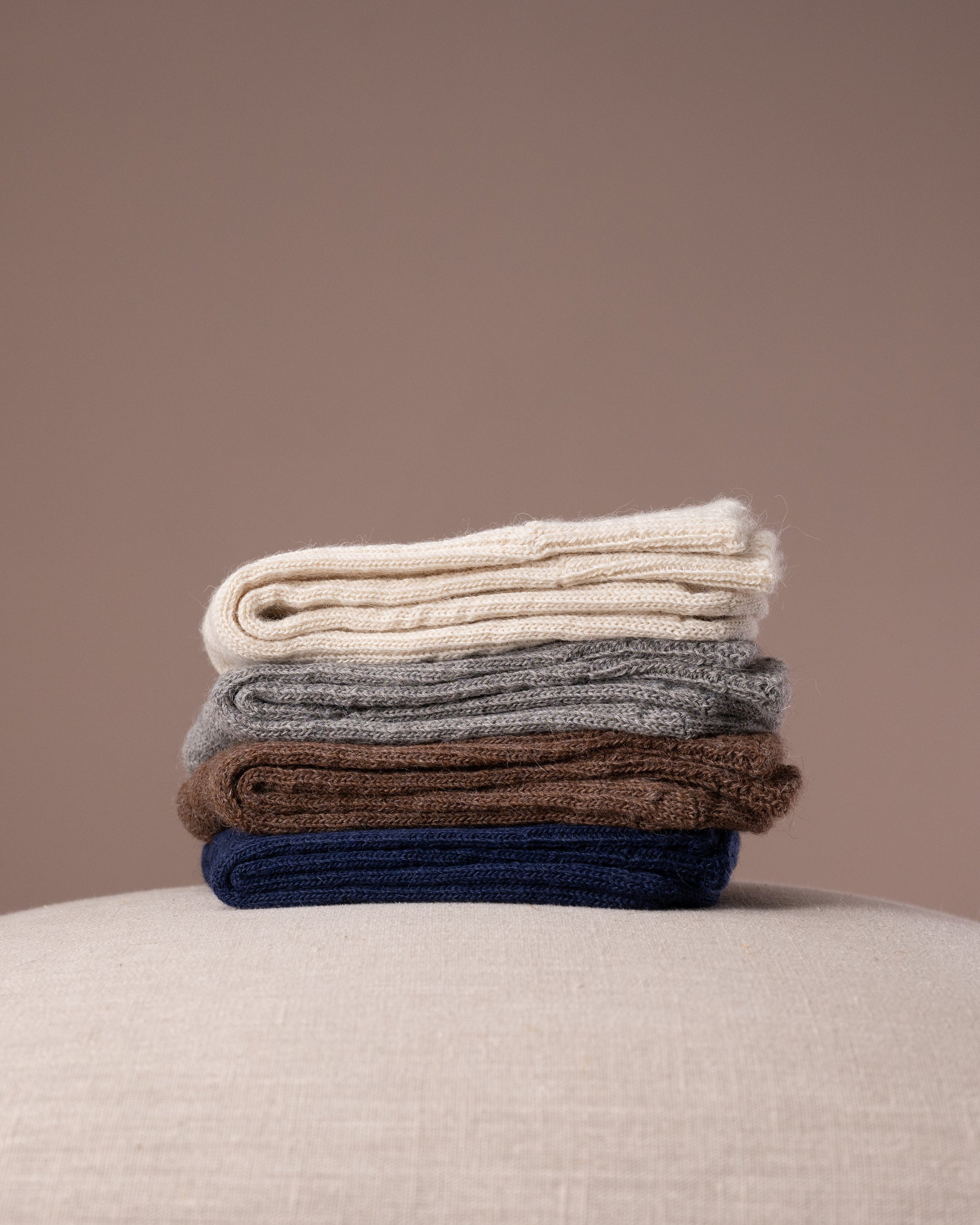 Stack of socks in various colours on a neutral background