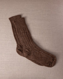 Brown socks on a beige textured fabric background