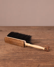 Wooden brush with black bristles on a wooden surface