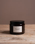Cook & Butler scented candle on a wooden table