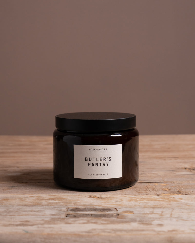 Cook & Butler scented candle on a wooden table