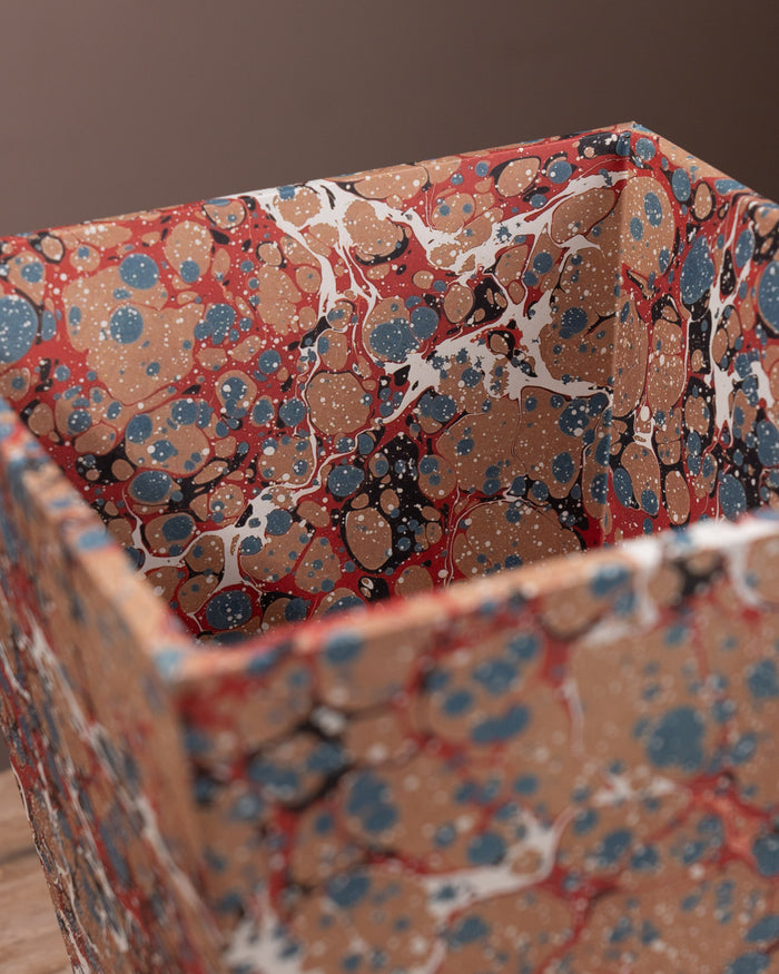 Marbled paper bin with a multicolored pattern on a brown background