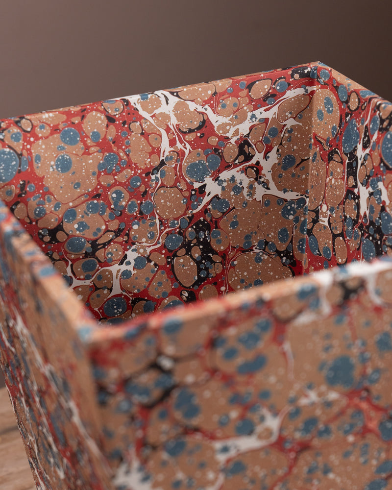 Marbled paper bin with a multicolored pattern on a brown background