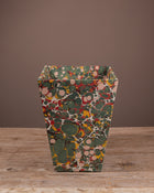 Decorative bin with a multicolored pattern on a wooden surface and brown background