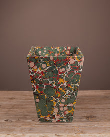 Decorative bin with a multicolored pattern on a wooden surface and brown background