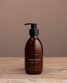 Brown bottle with black pump on a wooden surface and brown background