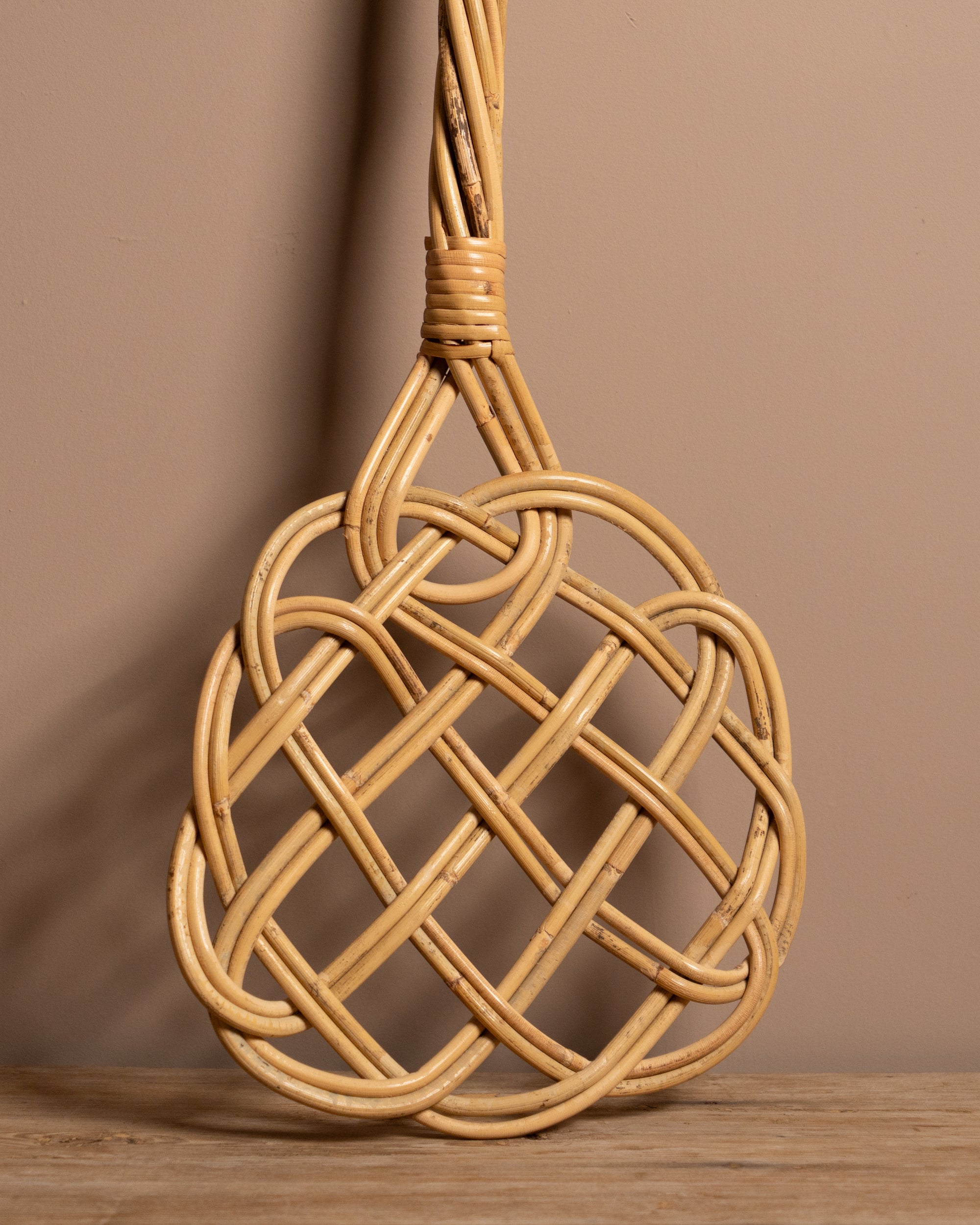 Carpet beater on a wooden surface with a brown background