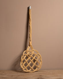 Carpet beater on a wooden surface and brown background