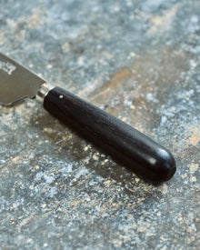 Black-handled knife on a textured surface