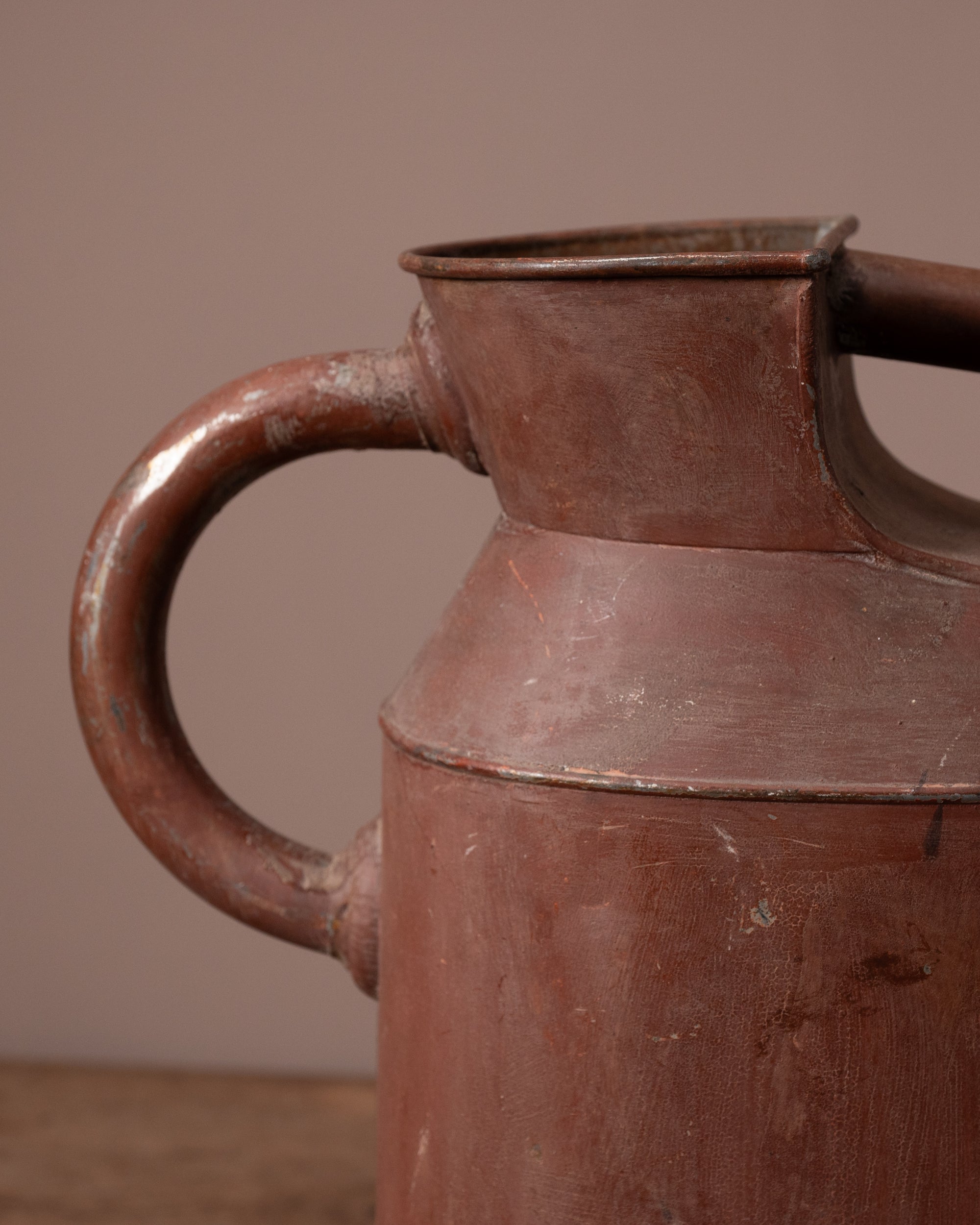 Close-up of a brown ceramic pitcher with a handle on a brown background