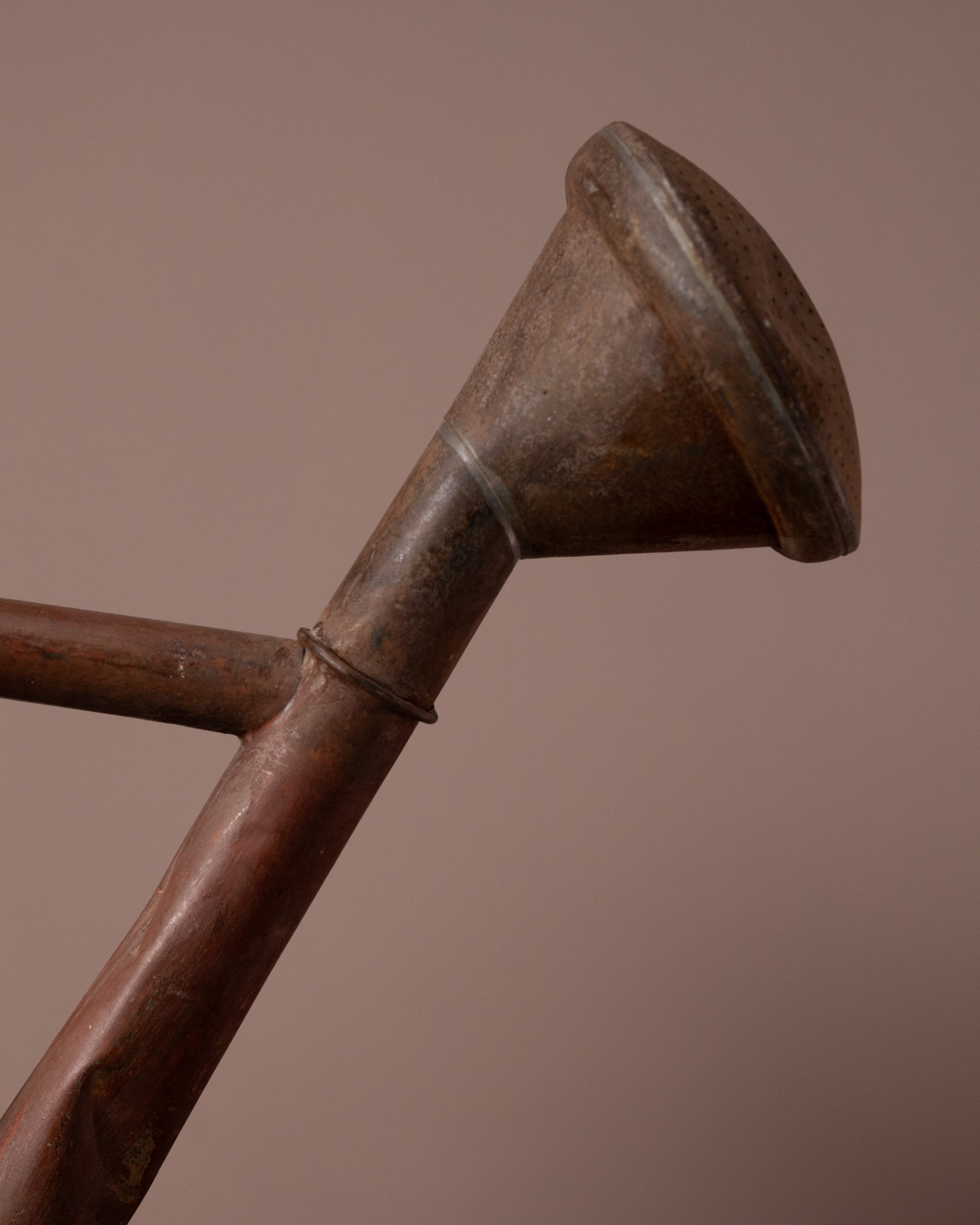Close-up of a metal funnel with a brown background