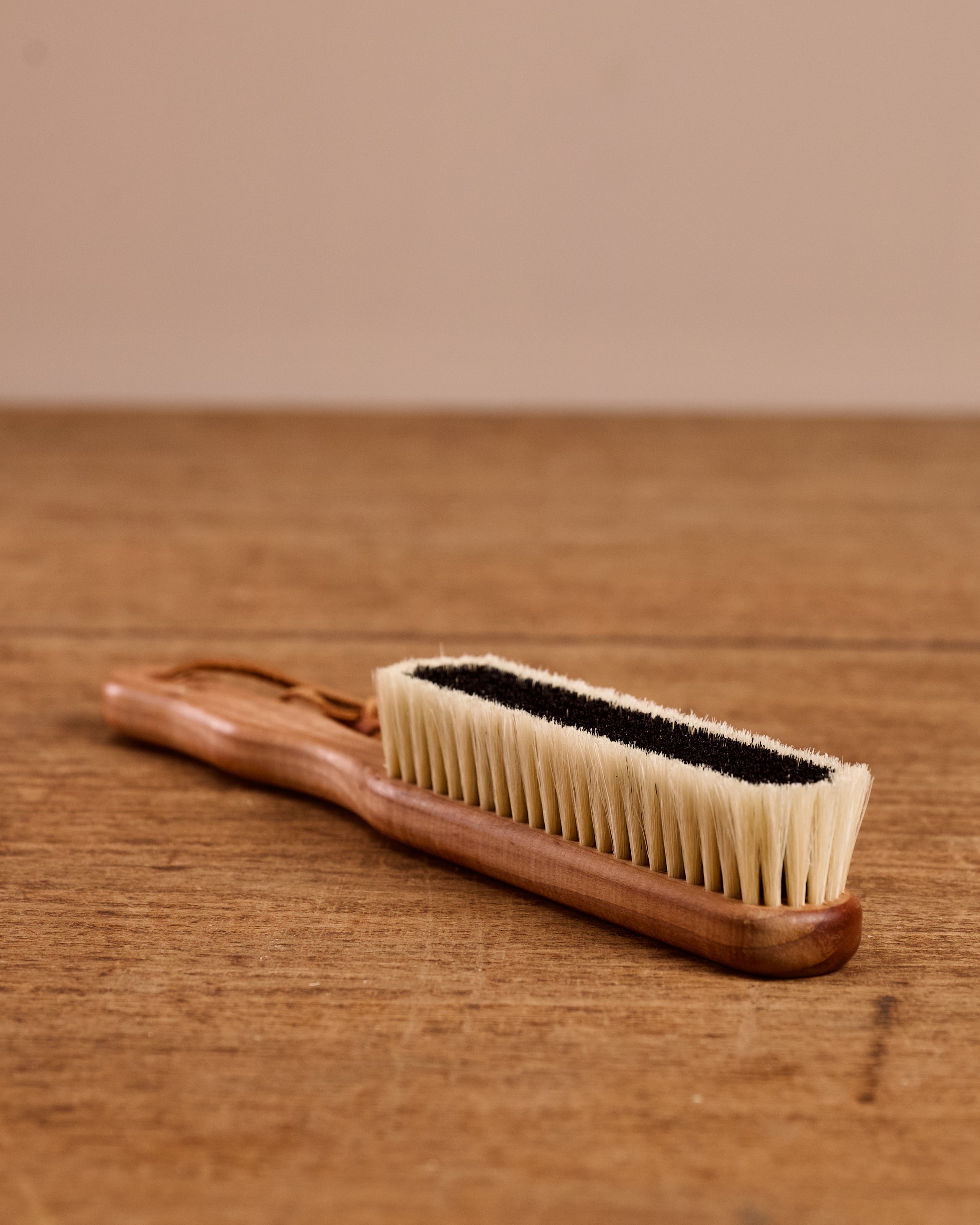 Wooden brush with bristle head on a wooden surface