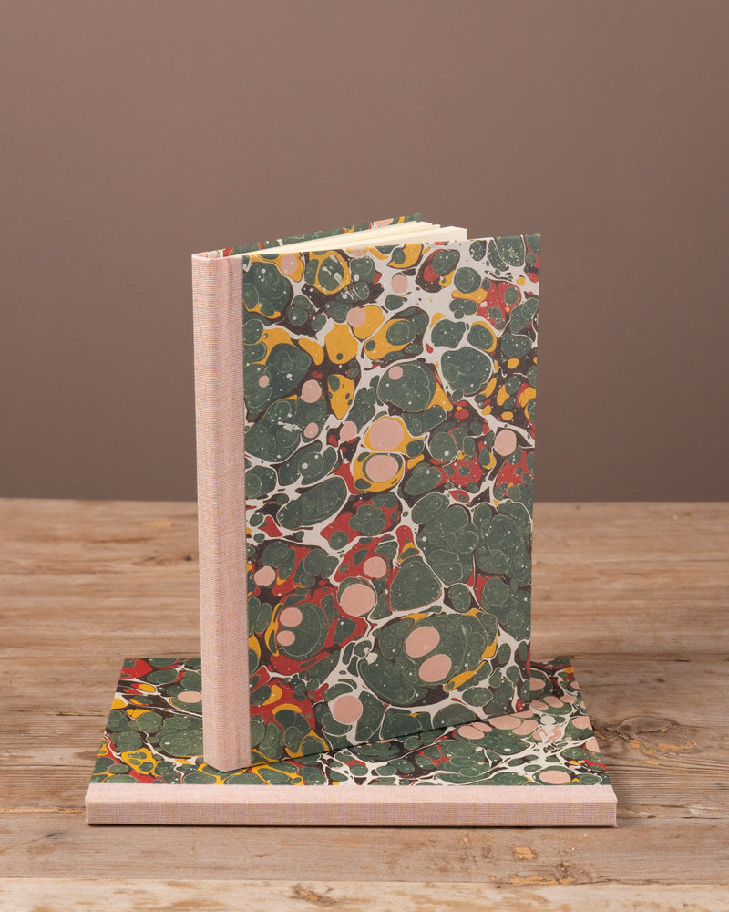 Marbled notebook and stand on a wooden surface with a brown background