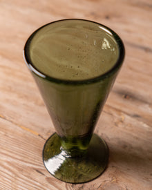 Green wine glass on a wooden surface