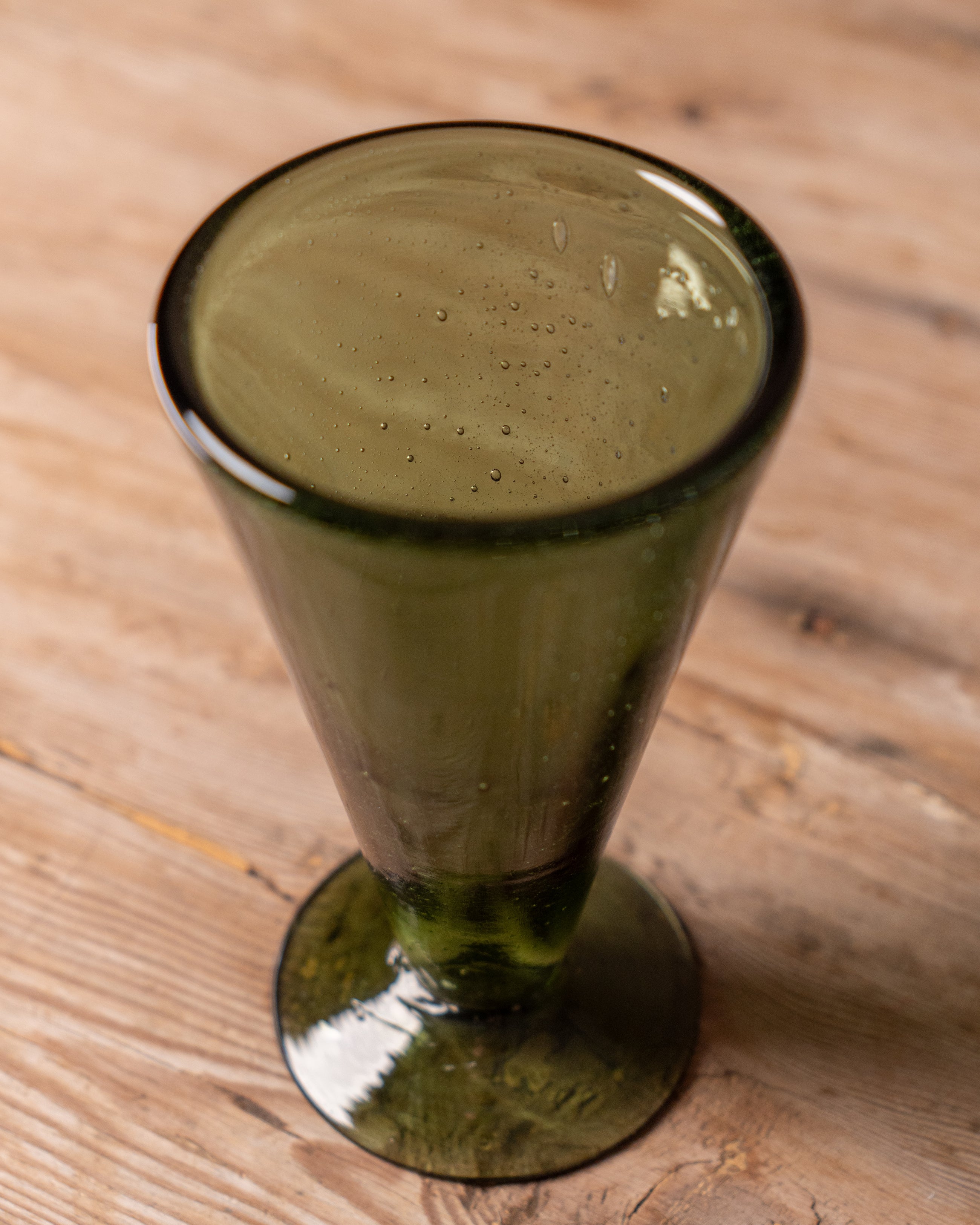 Green wine glass on a wooden surface