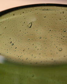 Close-up of a green glass with bubbles in a container