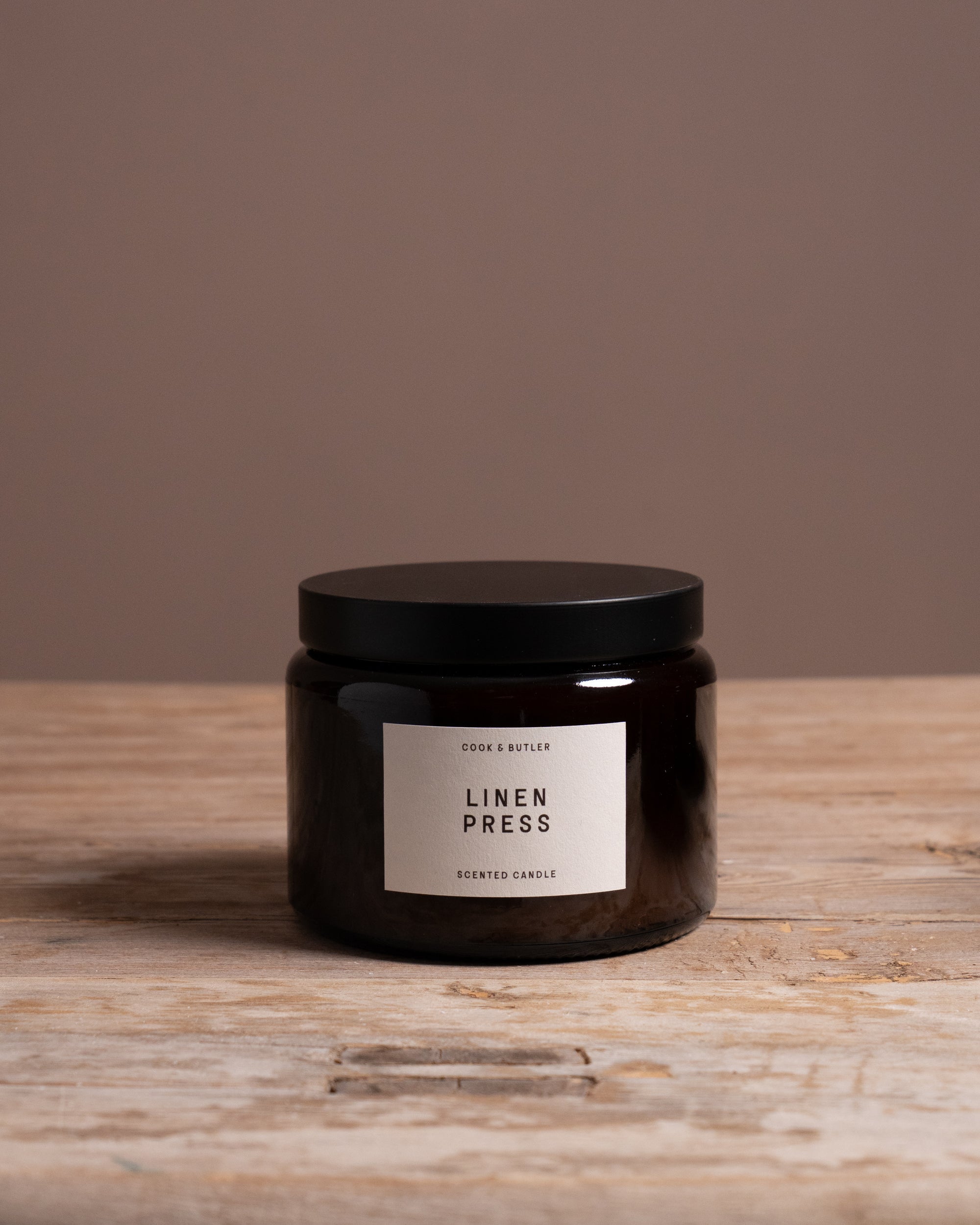 Cook & Butler scented candle on a wooden table