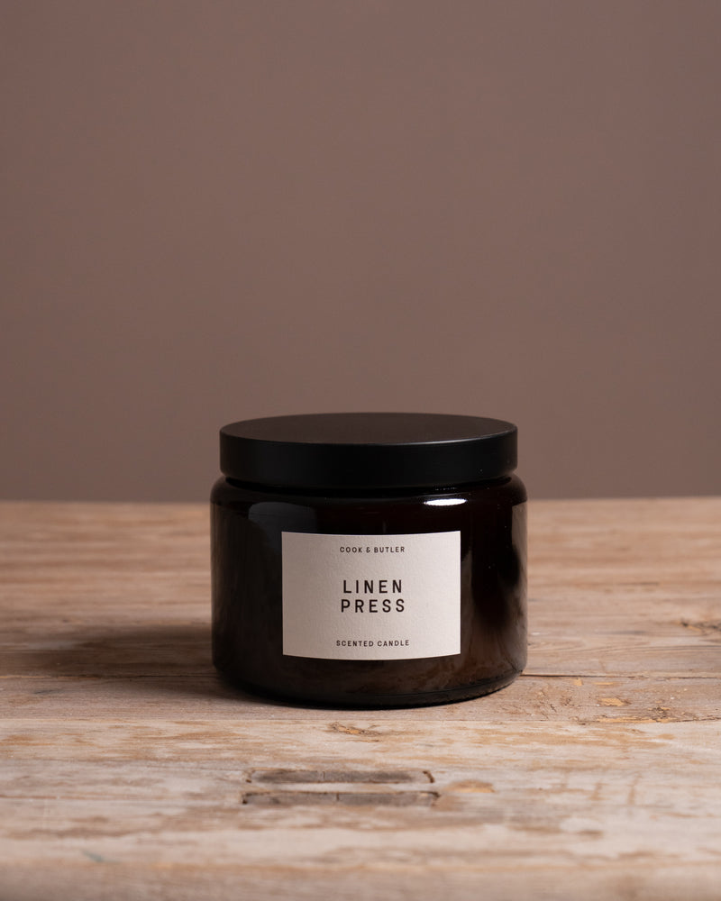 Cook & Butler scented candle on a wooden table