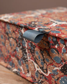 Close-up of a box wrapped in colourful patterned paper with a brown background