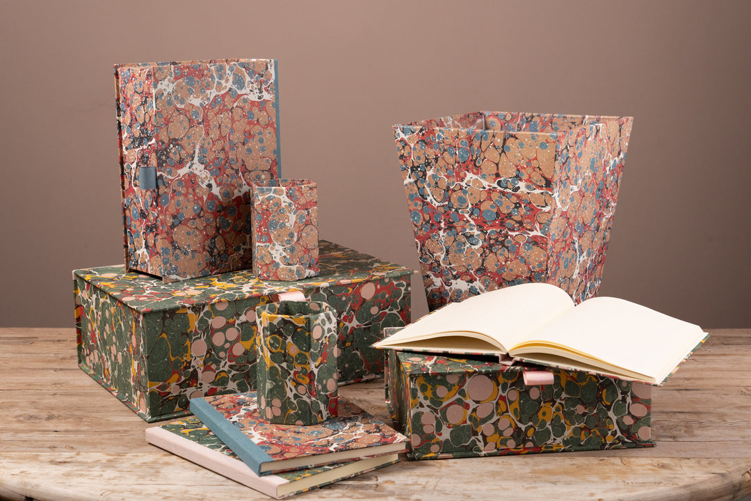 Selection of items covered in marbled paper on a wooden table top