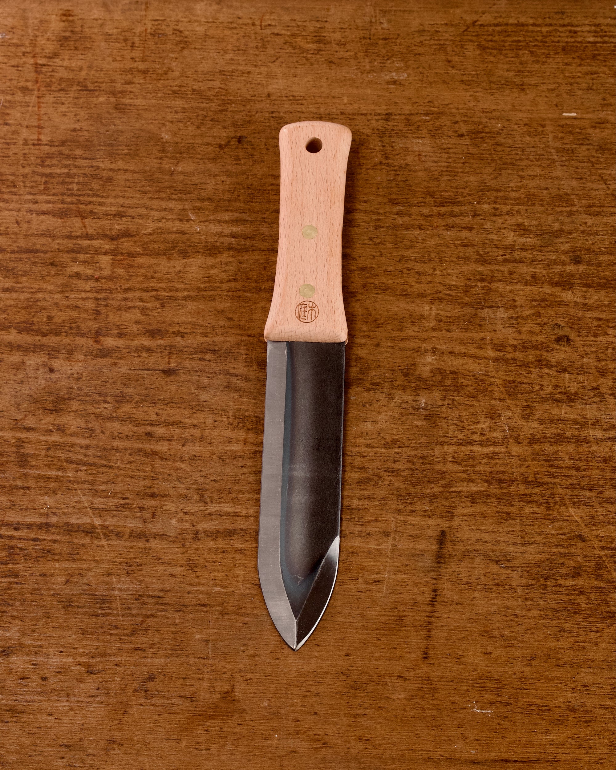 Niwaki Hori Hori garden knife on a wooden background