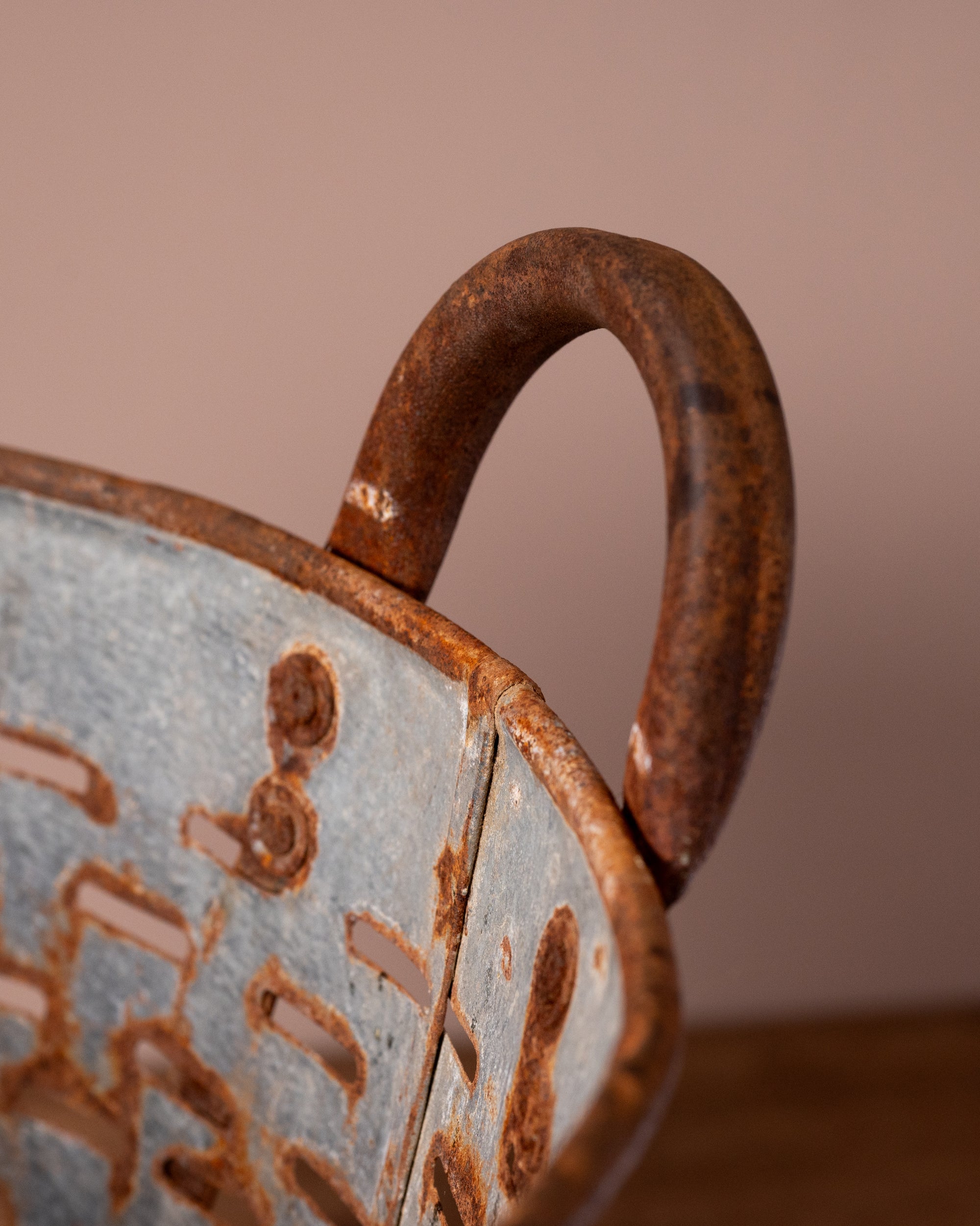 Close-up of a ceramic pot with a textured surface and brown handle against a blurred background