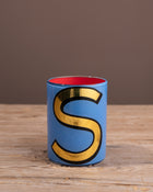 Painted brush pot with an S on the front