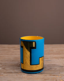Blue mug with yellow interior on a wooden surface
