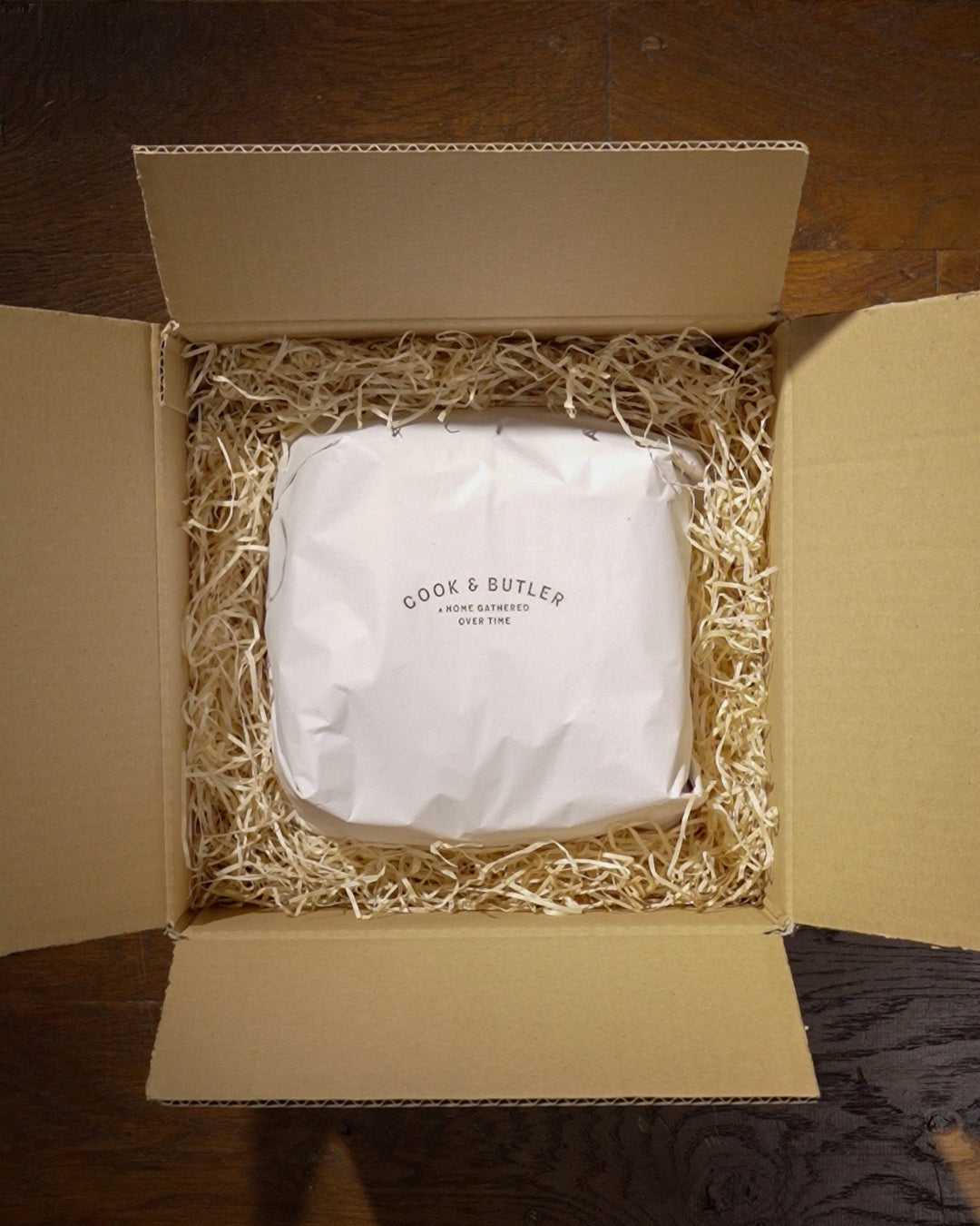 Panettone wrapped in white tissue paper and 'Cook & Butler' branding in a box