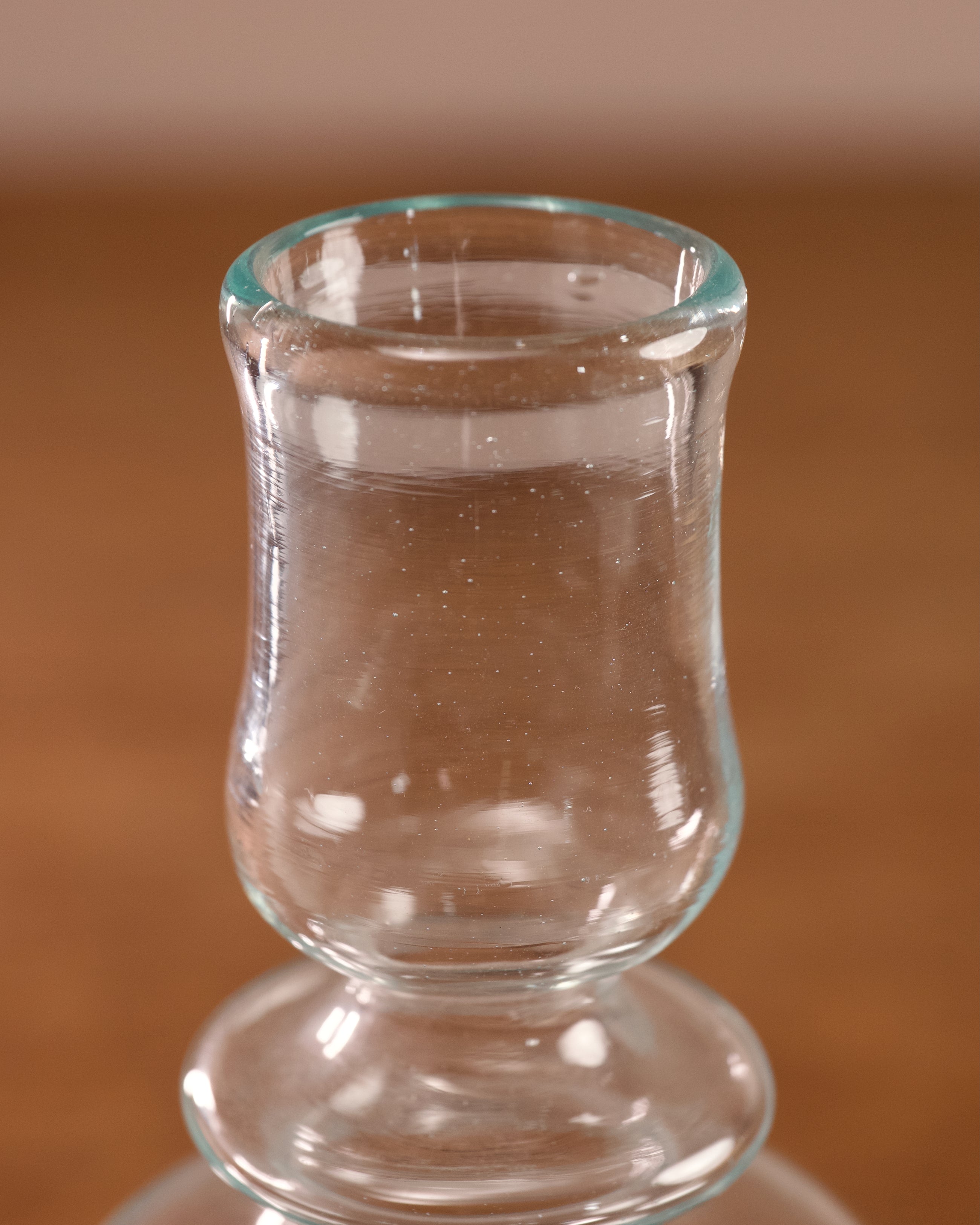 Clear glass shot glass on a brown surface