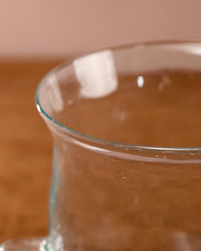 Clear glass container with a brownish liquid on a wooden surface