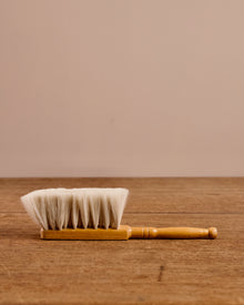 Wooden brush with white bristles on a wooden surface