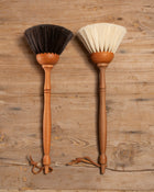 Two wooden brushes with bristle heads on a wooden background