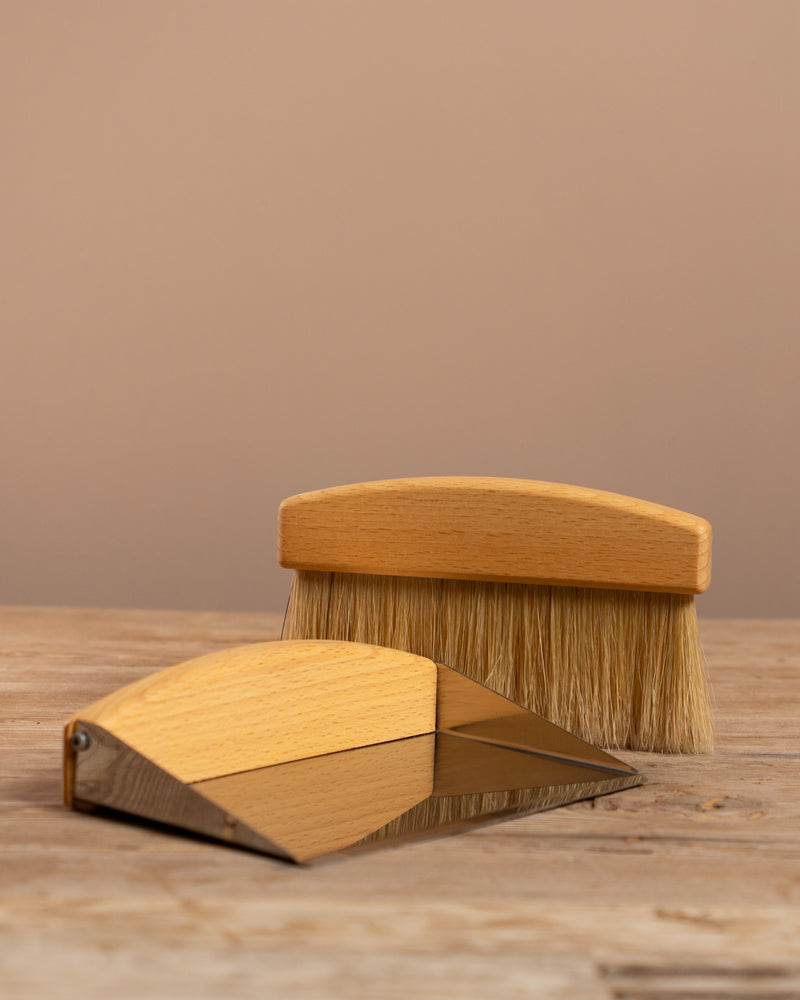 Wooden brush and block set on a wooden surface with a beige background