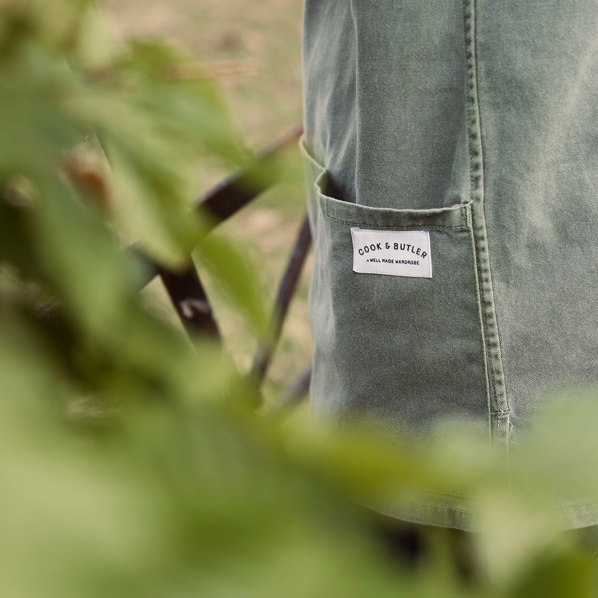 Green smock with a Cook and Butler brand label in a natural setting