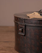 Vintage metal canister with a lid on a wooden surface