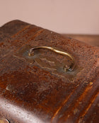 Close-up of a rusted metal object with a decorative brass handle.
