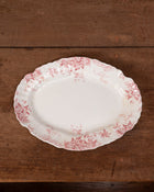 Decorative plate with pink floral pattern on a wooden surface