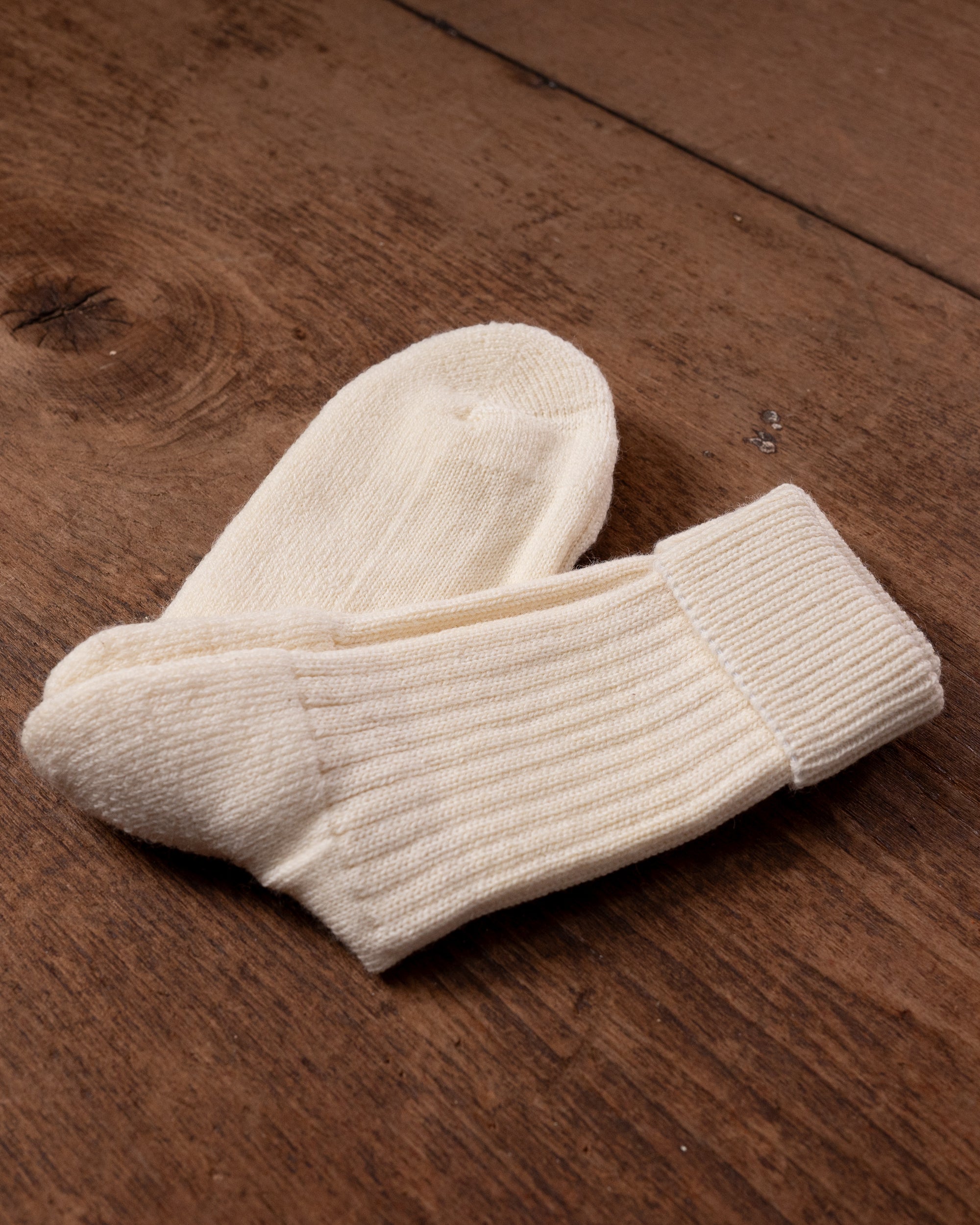 Pair of white socks on a wooden surface